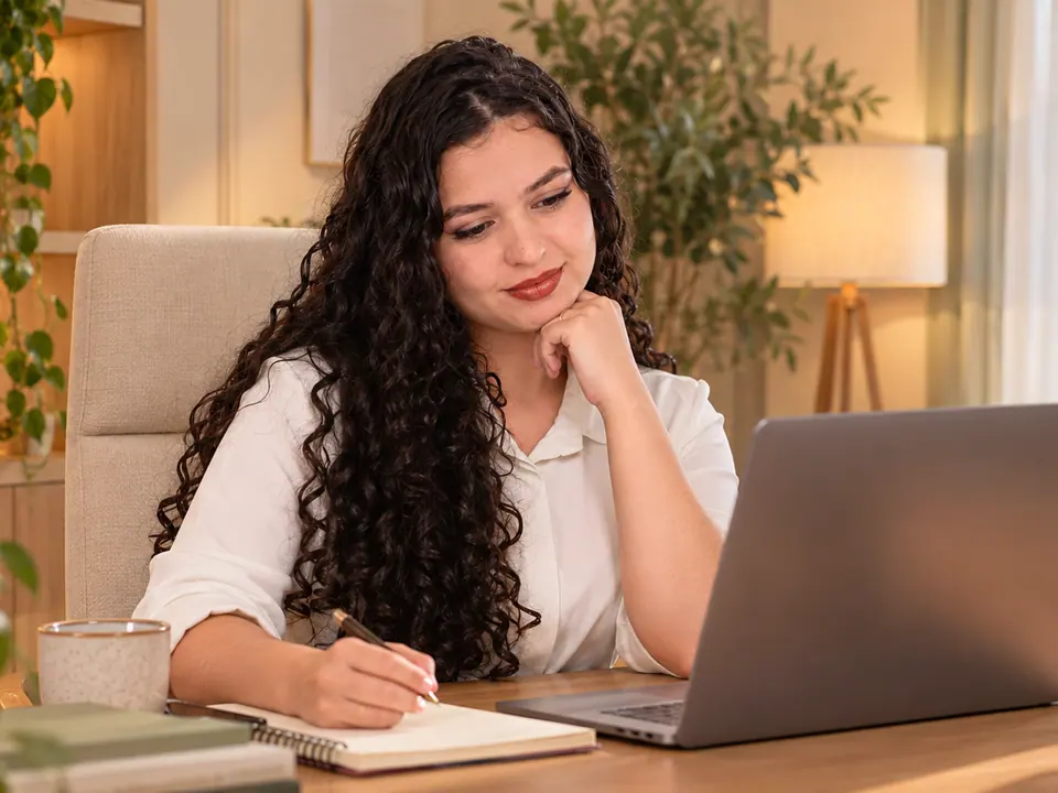 Kimberlly Pablinni, psicóloga, fazendo anotações diante do notebook